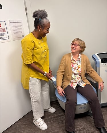 a woman on the BTL Emsella chair to strengthen pelvic muscles talking to dr aluko stony plain