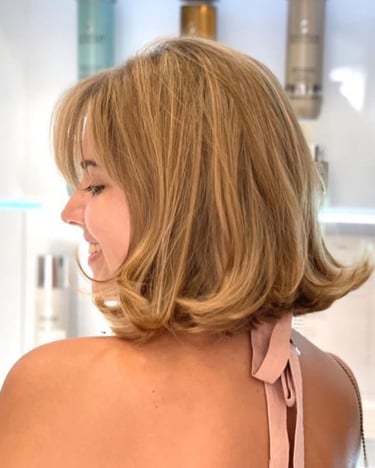 Corte bob haircut with soft flipped ends and curtain bangs.