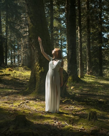 Photo fantasy d'une femme en robe longue au milieu d'une forêt