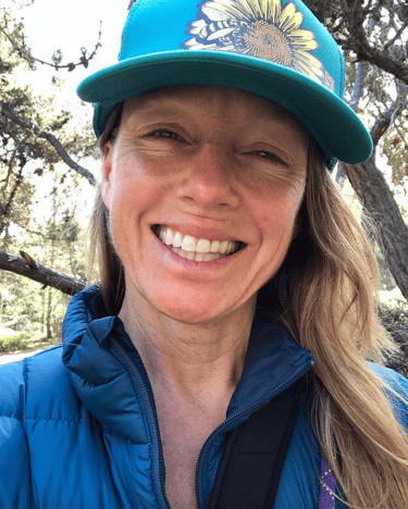 Jamie wearing hat in the woods smiling 2