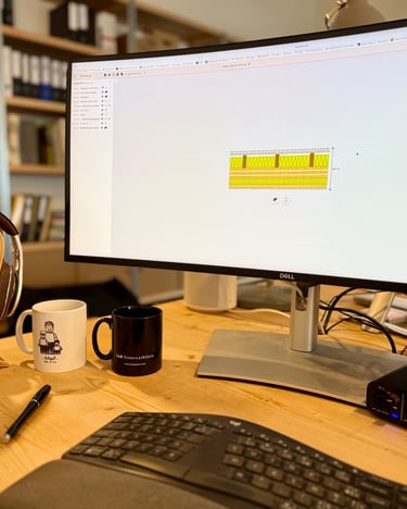 Bureau professionnel à domicile avec un moniteur Dell avec des dessins techniques, une interface aud