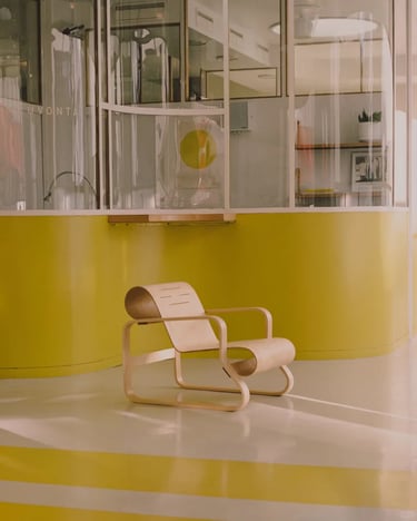 Pale wooden lounge chair in a bright modern interior, reflecting Alvar Aalto’s simple and functional
