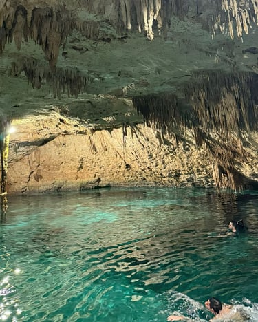 a person swimming in a cave with a person in the water
