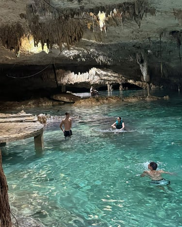 a group of people swimming in a cave