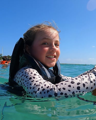 a girl in a polka dotty shirt is holding a dog