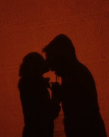 a man and woman kissing in a dark room