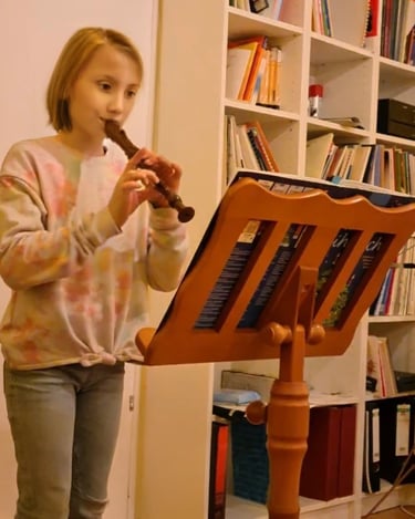 Ein junges Mädchen spielt auf einer Blockflöte