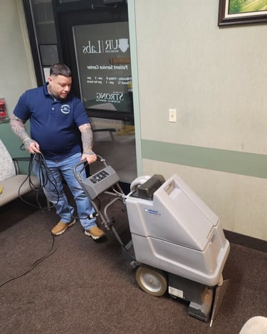 a man cleaning a carpet with a machine