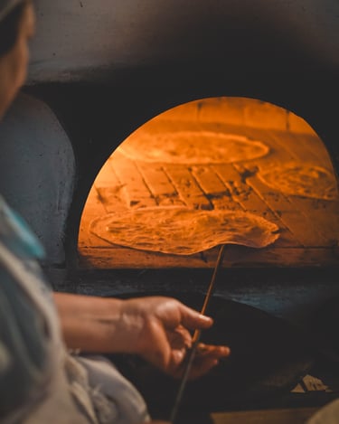 Traditional bread baking in Sardinia: a local woman cooks Pane Carasau in a wood-fired oven