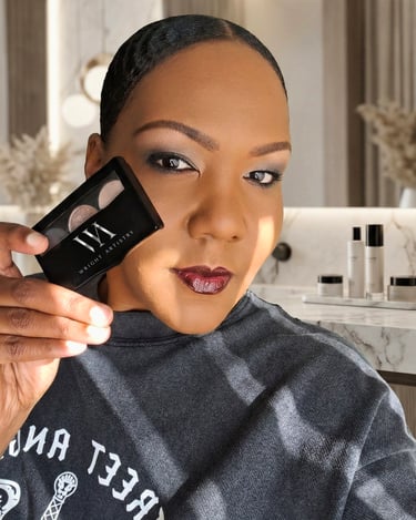 A woman with smokey eye makeup and dark lipstick holds a Wright Artistry eyeshadow palette.