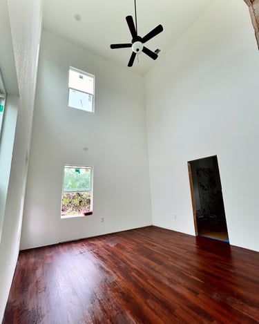 Primary bedroom with 20-foot ceilings and oversized windows in Texas custom home