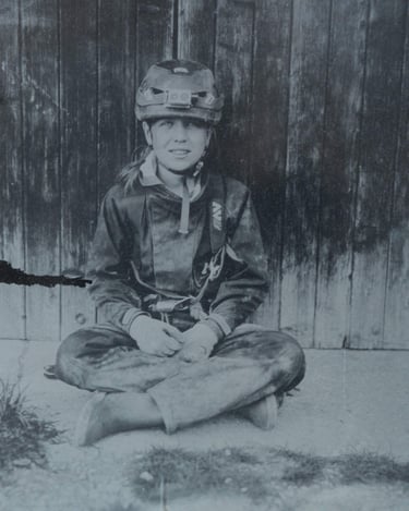 jeune fille habillée en spéléologue posant assise contre une porte