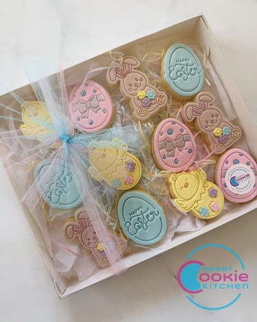A box of colorful Easter-themed sugar cookies, featuring bunnies, chicks, and eggs with "Happy Easter" greetings, perfect