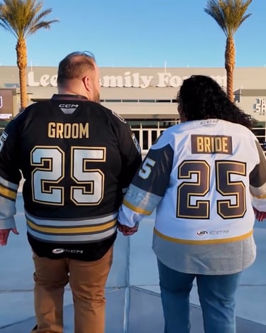 a man and woman holding hands and wearing matching hockey jerseys