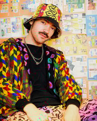 A man wearing colourful clothing, a necklace and a hat
