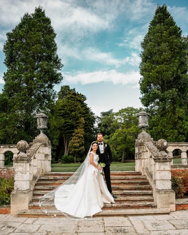 a bride and groom standing on a stone staircase