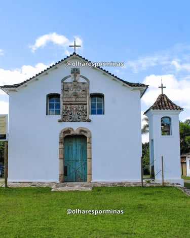 Capela de Santana em Chapada com fachada branca, porta azul e torre sineira em Ouro Preto MG