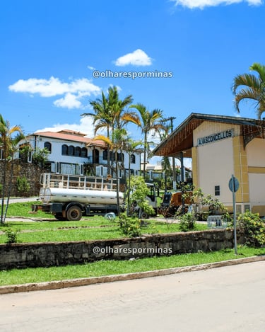 Vista lateral da estação ferroviária de Alfredo Vasconcelos com área verde e construções ao redor