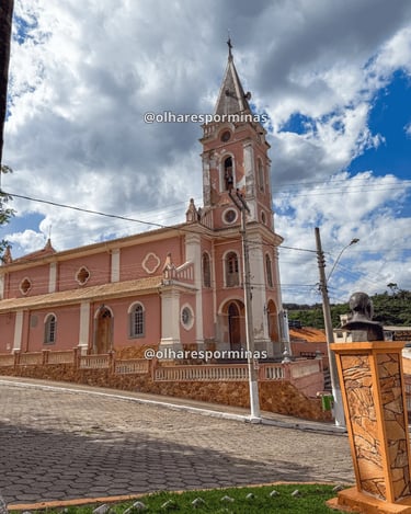 Igreja Matriz de Dores do Campo MG com fachada rosada e torre histórica