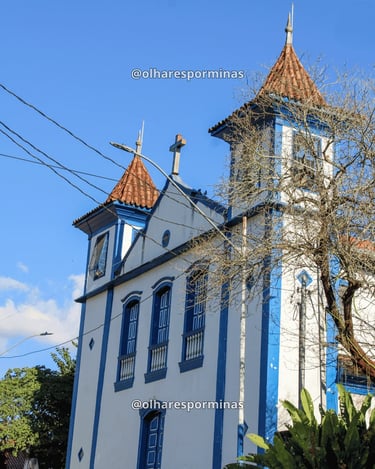 Vista lateral da Igreja Matriz de Ipoema MG com torres azuis e arquitetura colonial