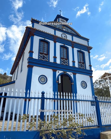 Igreja de Biribiri, em Diamantina, com fachada branca e azul e céu aberto