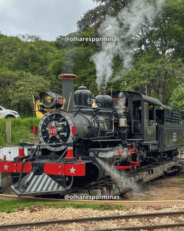 Locomotiva Maria Fumaça em Tiradentes com vapor saindo da chaminé e trilhos ao fundo