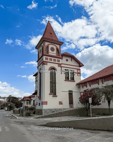 Museu da Loucura em Barbacena com torre em destaque, arquitetura histórica e céu azul com nuvens