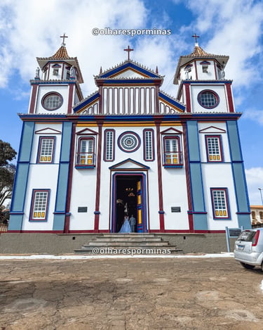 Igreja colorida no centro histórico de Datas MG com fachada colonial e céu azul