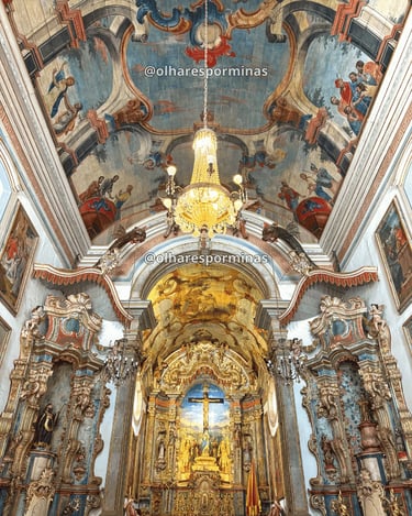 Interior do Santuário do Bom Jesus de Matosinhos em Congonhas, com altar dourado e pinturas no teto.