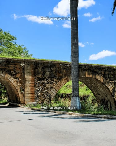 Pontilhão do Imperador em Alfredo Vasconcelos com arcos de pedra e céu azul em dia ensolarado
