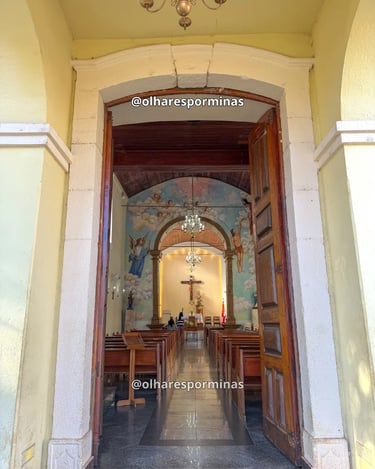 Entrada da Igreja Matriz de Itatiaiuçu revela bancos de madeira, altar e pinturas religiosas