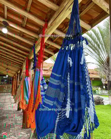 Redes artesanais coloridas em varanda de hospedagem ou espaço de descanso em Resende Costa