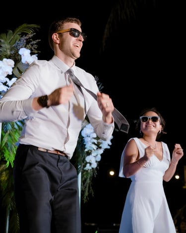 a man and woman in white dress clothes and sunglasses