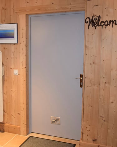 Porte de service grise avant réalisation du décor peint. Boiseries aux murs.