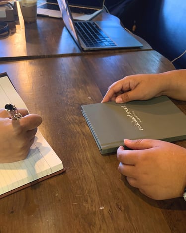 a person holding a book and a notebook