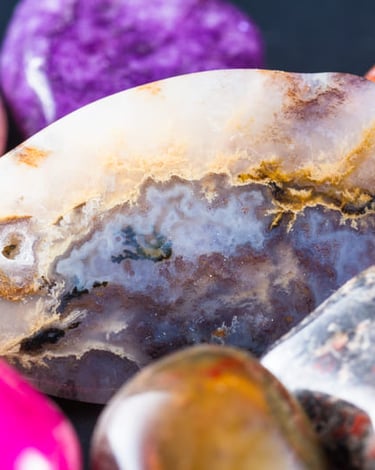 Primer plano de cristales curativos pulidos y piedras de ágata coloridas, con una variedad de patron
