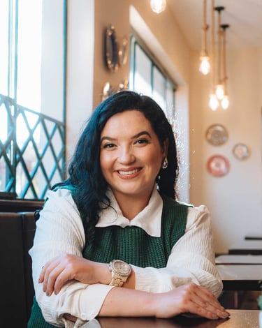 Raabe sorrindo com luzes pendentes ao fundo.