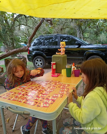 Crianças jogando cartas no acampamento