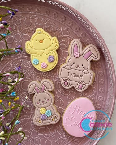 Custom Easter sugar cookies featuring a baby chick, bunnies, and a pink egg on a decorative tray.