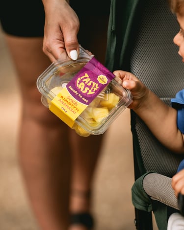 vaikas ir mama laiko pjaustytų ananasų indelį