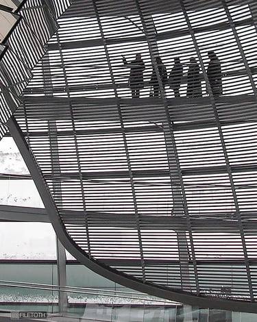 Soft winter daylight filters through glass panels as visitors ascend the spiral ramp inside the Reichstag dome.