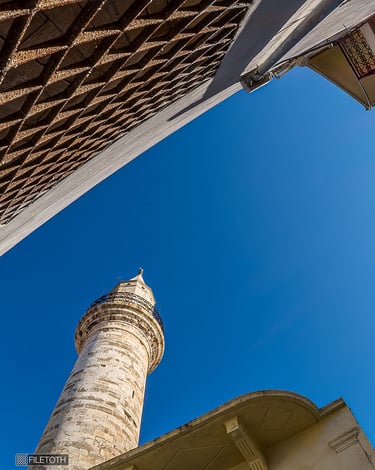 The Ahmet Ağa Minaret rises above Chania’s narrow streets as daylight filters through the historic lane.