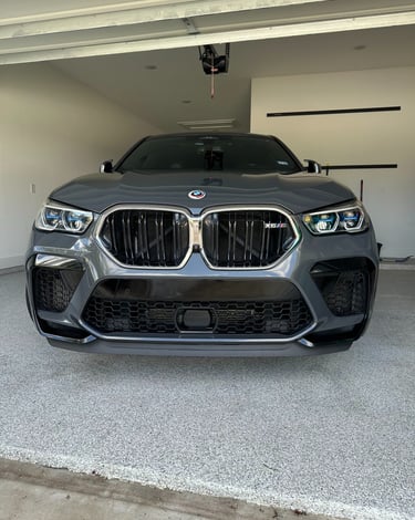 Front view of a grey BMW X6 M Competition SUV after a hand wash and detail.