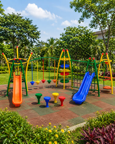 Colorful children's outdoor playground equipment with slides and climbing frames on safety rubber tiles.