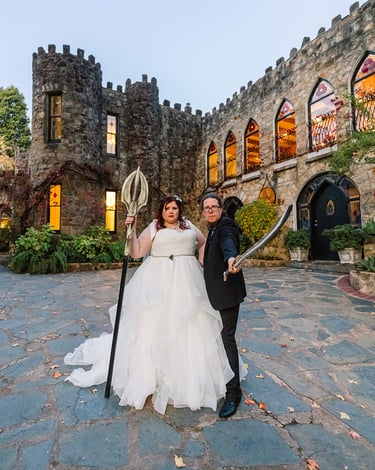 Bride and Groom stand in front of a castle holding swords. Castle is Manor Basket Range Adelaide