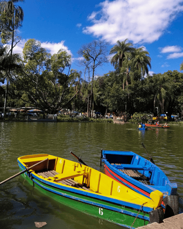 Barcos azul e amarelo em uma lagoa com o céu azul no Parque Municipal de BH