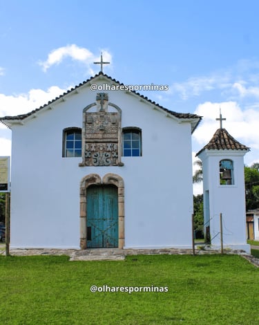 Capela de Santana em Chapada com fachada branca, porta azul e torre sineira em Ouro Preto MG
