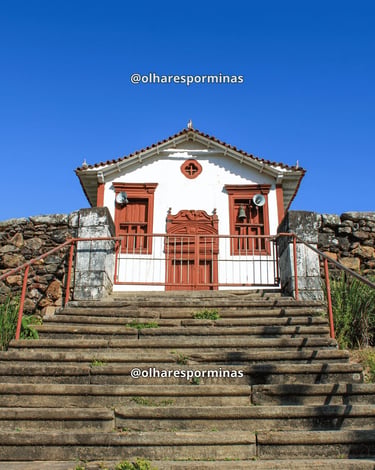 Capela de Nossa Senhora do Rosário em Itapanhoacanga MG, com fachada colonial branca e vermelho