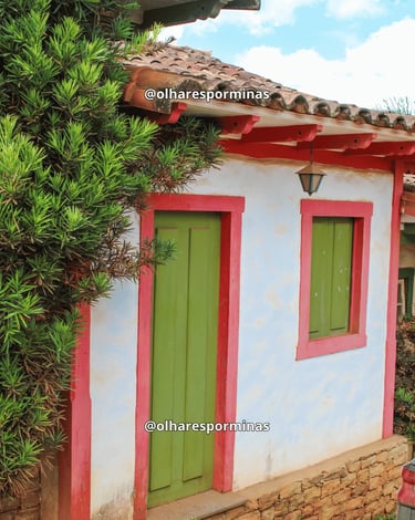 Casa histórica com portas verdes e detalhes coloridos em Lavras Novas, distrito de Ouro Preto