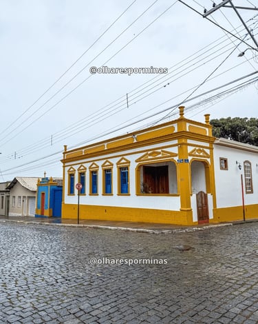 Casarão histórico em Entre Rios de Minas MG com fachada amarela e rua de pedra